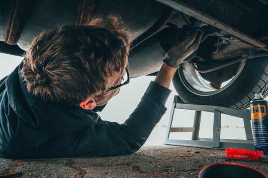 Man working on underside of car, mechanic